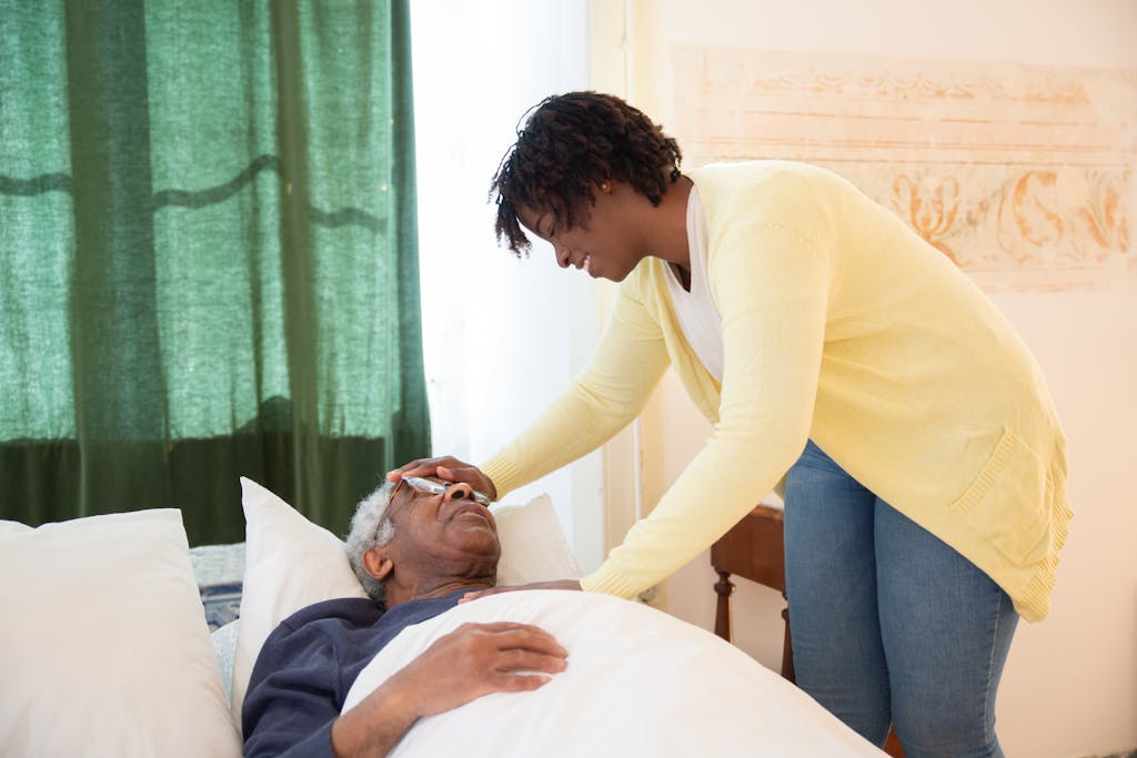 A loving daughter tends to her elderly father at home, offering comfort and care.