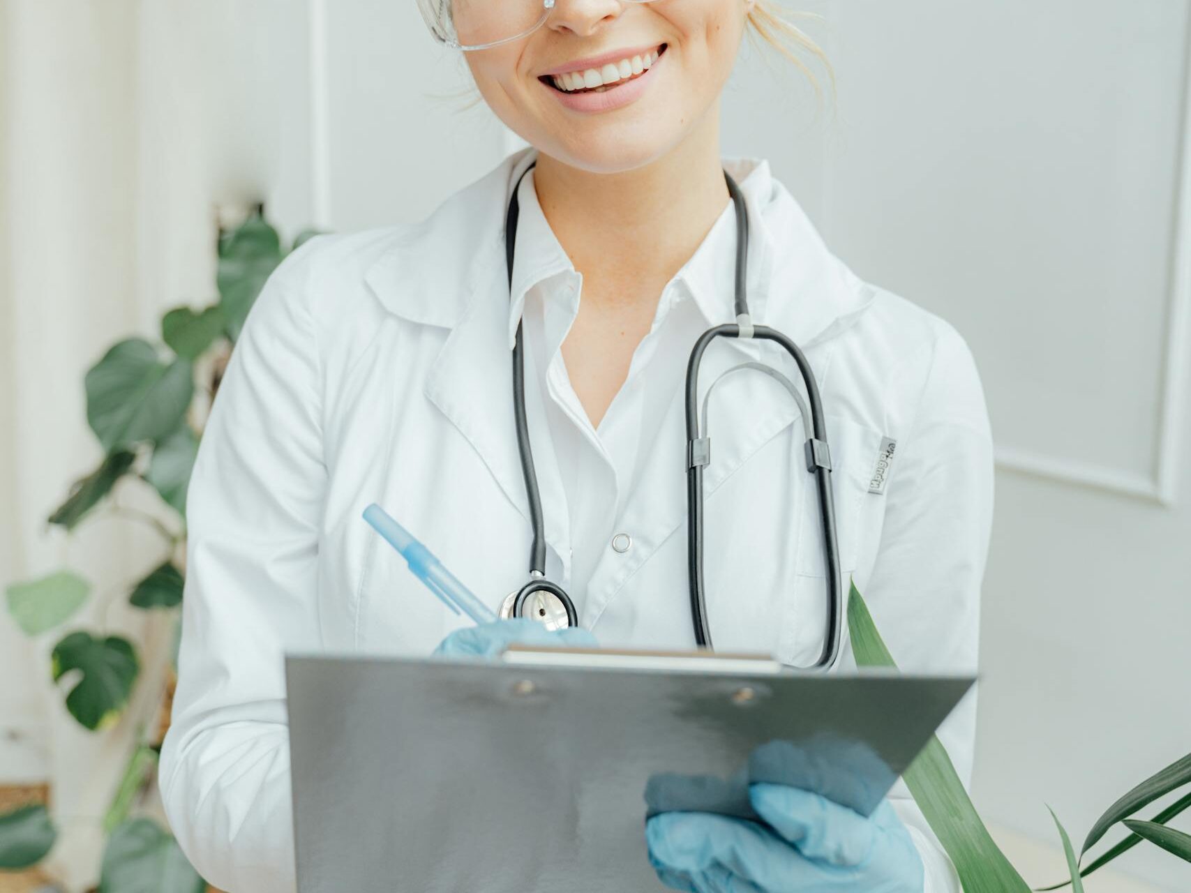 Confident female doctor with clipboard in a bright medical office.