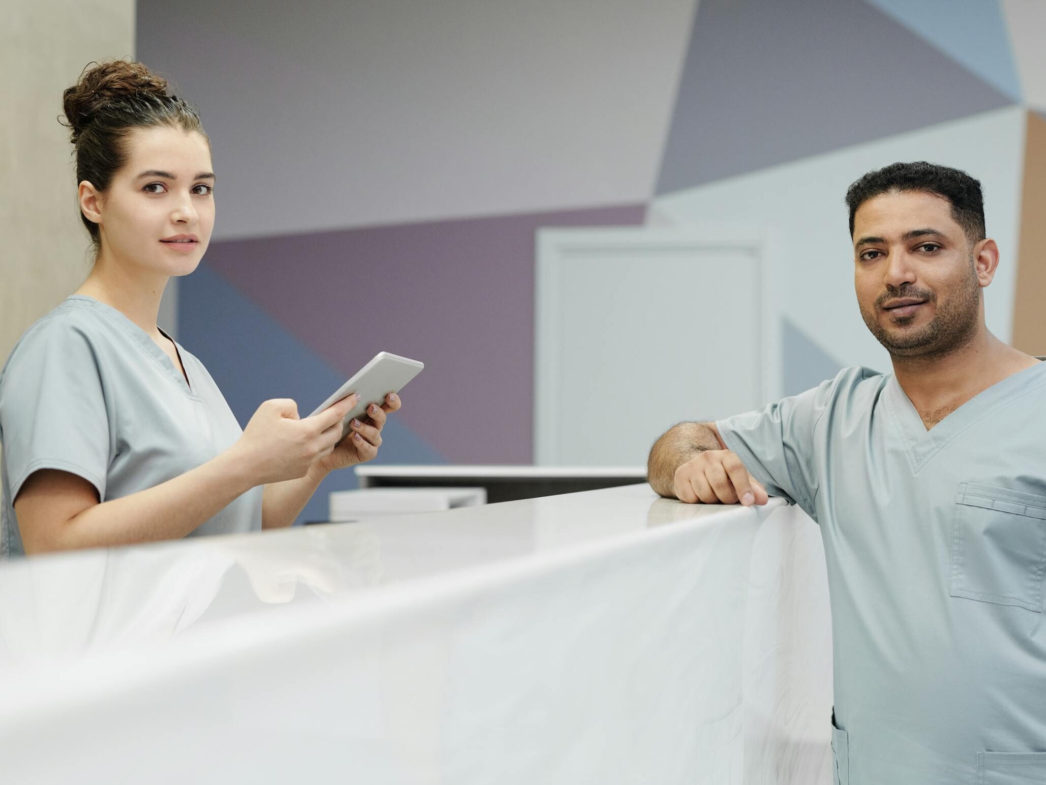 Medical staff members in scrub suits at a modern clinic's reception area.
